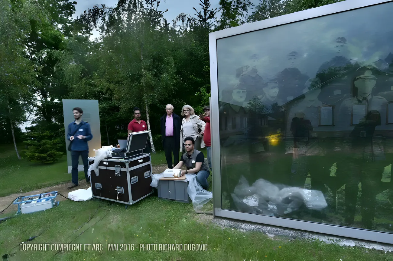 The Société du Spectacle team beside the rig and a projection panel at the memorial
